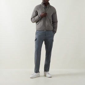 Model wearing Brunello Cucinelli Olive Casual Jacket with zip closure, styled with grey cargo trousers and white trainers.