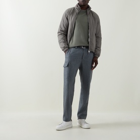 Model wearing Brunello Cucinelli olive casual jacket, styled with grey cargo trousers, green sweatshirt and white trainers.
