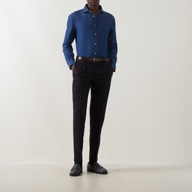Model wearing B Cucinelli dark wash denim cotton casual shirt, styled with black tapered trousers, brown leather belt and dark loafers