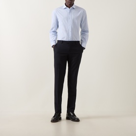 Model wearing B Cucinelli blue cotton casual shirt with spread collar, styled with black tailored trousers and black leather shoes.