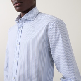 Model wearing B Cucinelli blue and white stripe cotton casual shirt with spread collar, close-up view.