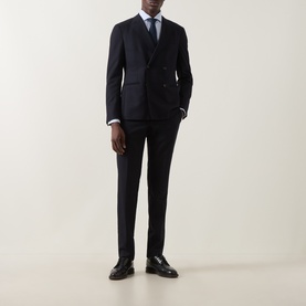 Model wearing B Cucinelli blue cotton casual shirt, styled with a navy double-breasted suit and dark leather loafers.