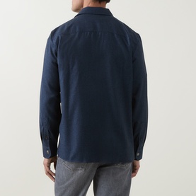 Model wearing B Cucinelli blue virgin wool casual shirt, rear view, with grey trousers