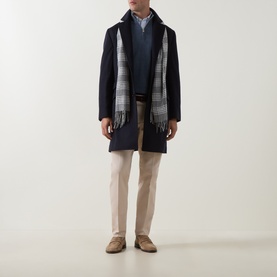 Model wearing B Cucinelli navy virgin wool coat, styled with grey check scarf, navy jumper and stone chinos.