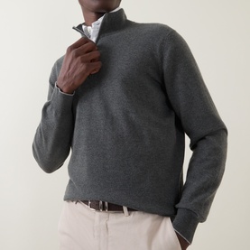 Model wearing B Cucinelli Dark Green cashmere half-zip jumper, styled with white shirt and stone chinos