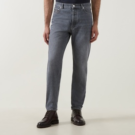 Model wearing Brunello Cucinelli grey cotton jeans in a straight fit, styled with dark brown leather lace-up boots.
