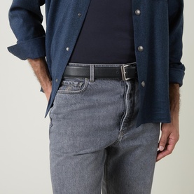 Model wearing Brunello Cucinelli grey cotton jeans styled with a dark navy shirt and black leather belt
