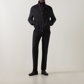 Model wearing black zip-up harrington-style jacket with stand collar, styled with black trousers and black leather shoes