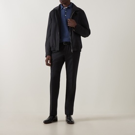Model wearing a navy zip-up jacket with blue polo shirt, dark tailored trousers, and black leather shoes