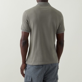 Model wearing B Cucinelli Logo Pique Polo Shirt in Army Wash, rear view, short sleeves, styled with grey cargo shorts