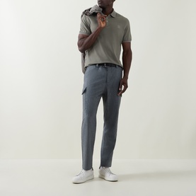 Model wearing Brunello Cucinelli Logo Pique Polo Shirt in Army Wash, styled with grey cargo trousers and white trainers.