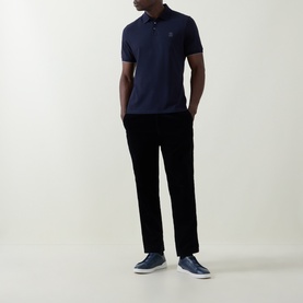 Model wearing Brunello Cucinelli Logo Pique Polo Shirt in Cadet, paired with black trousers and navy trainers