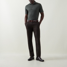Model wearing B Cucinelli Solid Knitted Polo Shirt in Military Green, styled with dark brown trousers, leather belt and shoes.