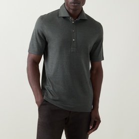 Model wearing B Cucinelli Solid Knitted Polo Shirt in Military Green, short sleeves, polo collar with button fastenings, styled with dark trousers