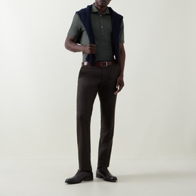 Model wearing Brunello Cucinelli Military Green Solid Knitted Polo Shirt, styled with dark brown trousers and a leather belt.