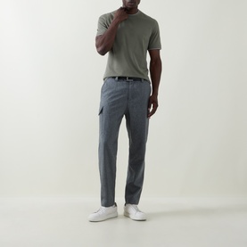 Model wearing Brunello Cucinelli grey virgin wool cargo trousers with a sage green polo shirt and white trainers.