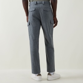 Model wearing Brunello Cucinelli grey virgin wool cargo trousers, rear view, styled with white trainers.