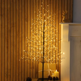 Noma 1.2m Micro LED Black Twig Tree with 600 warm white LEDs, styled indoors against wooden slat wall with candles nearby.