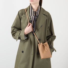 Model carrying Strathberry Osette Midi Pouch Bag in caramel grained leather with gold-tone hardware and narrow crossbody strap, styled with olive