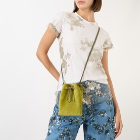Model carrying Strathberry Osette Midi Pouch in lime suede with khaki crossbody strap, drawstring fastening and gold-toned hardware.