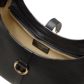 Strathberry black grain calf leather shoulder bag, open top view showing cream interior lining and gold-tone ring hardware detail.