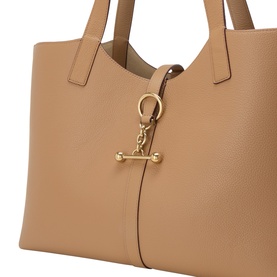 Strathberry Kite Leather Tote Bag in caramel grained calf leather, close-up of signature Music Bar hardware charm with gold-tone finishes
