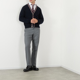 Model wearing Thom Browne navy wool-mohair cardigan with striped tie, white shirt, and grey pinstripe trousers with black leather shoes.
