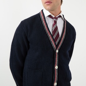 Model wearing Thom Browne navy wool-mohair cardigan with red and white stripe trim, styled with white shirt and striped tie.