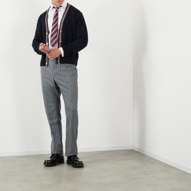 Model wearing Thom Browne navy wool-mohair cardigan with white shirt, striped tie, grey pinstripe trousers and black leather shoes.