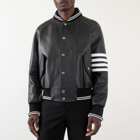 Model wearing Thom Browne 4-Bar Leather Bomber Jacket in black with white ribbed trims and signature 4-bar stripe at sleeve