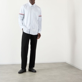 Model wearing Thom Browne medium grey striped cotton casual shirt with signature arm bands, styled with black trousers and loafers