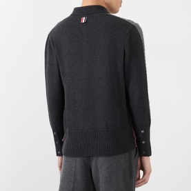 Model wearing Thom Browne Tonal Grey wool polo knitwear, rear view, with signature tricolour tab and button cuffs.