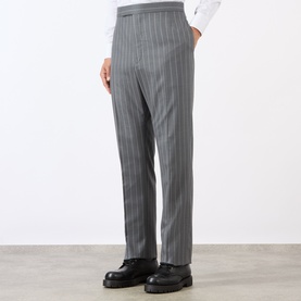 Model wearing Thom Browne Back Strap Pinstripe Trousers in medium grey wool, slim-leg with covered waistband, styled with black leather shoes.