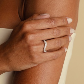 Model with Astrid & Miyu ring in 18ct gold, featuring a curved band pav&eacute;-set with white stones