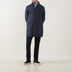 Model wearing Herno Blu Navy down coat with button front, styled with black trousers and navy trainers.