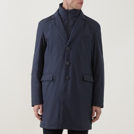 Model wearing Herno Blu Navy coat with button front, patch pockets, and visible zip-up inner layer.
