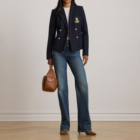 Model wearing Lauren navy blazer with gold buttons and crest emblem, styled with blue jeans, white top, and tan bag