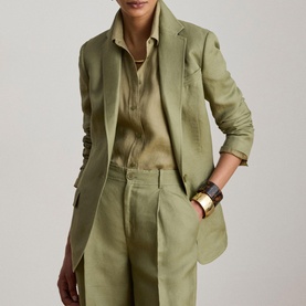 Model wearing Lauren Light Agave linen blazer with matching wide-leg trousers and open-collar shirt, gold cuff bracelet