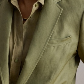 Model wearing Lauren Light Agave linen blazer, close-up showing chest pocket and open-front styling, paired with matching trousers