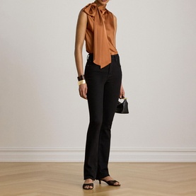 Model wearing Lauren Red Terracotta sleeveless blouse with bow neck, styled with black flared trousers and strappy heeled sandals