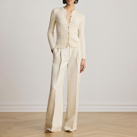 Model wearing Lauren Mascarpone Cream cable-knit cardigan with button front, styled with wide-leg cream trousers