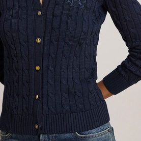 Model wearing Lauren navy cable-knit cardigan with gold buttons and tonal embroidered logo, styled with blue jeans
