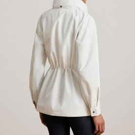 Model wearing Lauren Mascarpone Cream coat, rear view showing cinched waist, long sleeves with button cuffs, styled with dark trousers