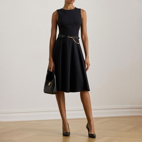 Model wearing Lauren black sleeveless midi dress with gold chain belt detail, styled with black heels and small black handbag