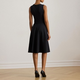 Model wearing Lauren black sleeveless fit-and-flare dress, rear view, styled with black heels.
