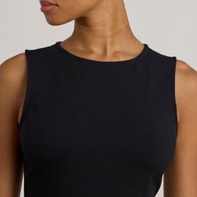 Model wearing Lauren black dress, close-up of sleeveless crew neck bodice detail
