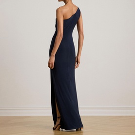 Model wearing Lauren navy one-shoulder maxi dress with side slit, viewed from the back