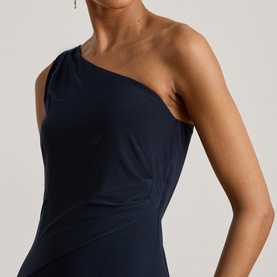Model wearing Lauren navy one-shoulder dress, styled with drop earrings, close-up showing draped neckline detail