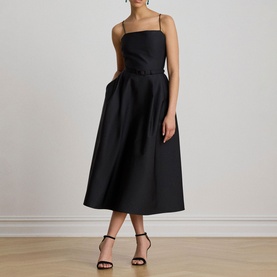 Model wearing Lauren black midi dress with square neckline, thin straps, and full pleated skirt, styled with black strappy heels