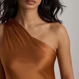 Model wearing Lauren Red Terracotta one-shoulder satin dress, close-up of draped neckline detail